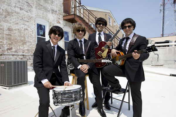 Beatles cover band for events posing outside with their instruments for a promo shot | Altus Entertainment